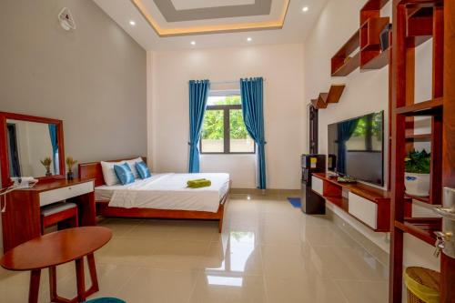 a bedroom with a bed and a window and a television at Garden House Côn Đảo in Con Dao