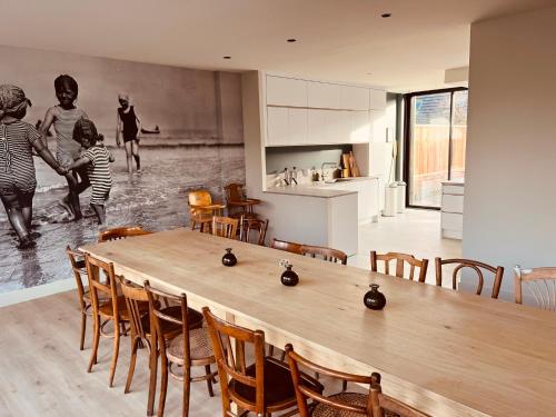 une cuisine et une salle à manger avec une table et des chaises en bois dans l'établissement MALO - VUE MER - 15 pers - ROOF TOP panoramique, à Dunkerque