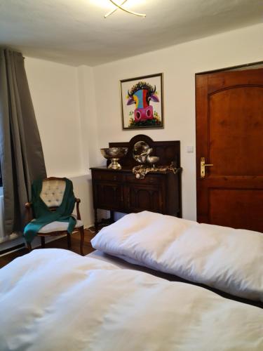 a bedroom with a bed and a chair and a wooden door at Pilgrims Gästeapartements in Meschede
