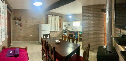 a kitchen and dining room with a table and chairs at Cabañas El Descanso in Potrero de Garay