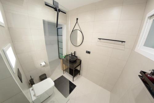 a bathroom with a white toilet and a mirror at 31 Apartments - Luxe in het centrum van Malaga in Málaga