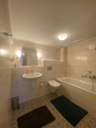 a bathroom with a tub and a toilet and a sink at Hotel Restaurant Hestia in Eijsden