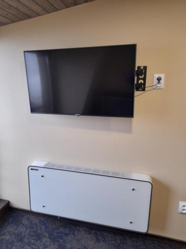 einen Flachbild-TV, der an einer Wand hängt in der Unterkunft OZONE in Petroşani