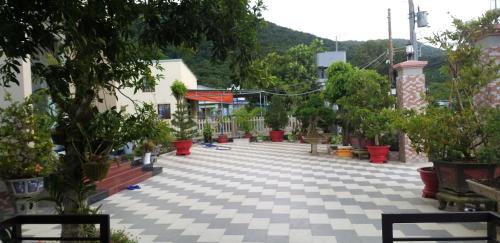 an empty courtyard with potted plants and trees at Garden House Côn Đảo in Con Dao