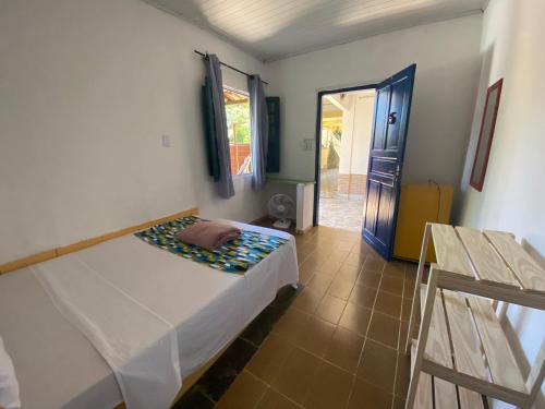 a bedroom with a bed and a door to a hallway at Pousada Korui in Abraão