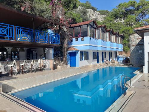 a swimming pool in front of a building with a house at Belle Vue Ölüdeniz in Fethiye