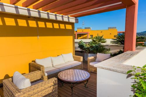 a patio with a couch and chairs and a table at Albamar Duplex Apartment Javea Arenal by Rock Rentals in Jávea