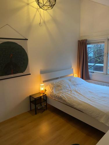a bedroom with a bed and a window and a table at Lovely family house nearby Amsterdam and Schiphol in Almere