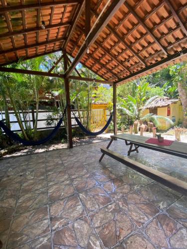 an outdoor patio with a table and a hammock at Pousada Korui in Abraão