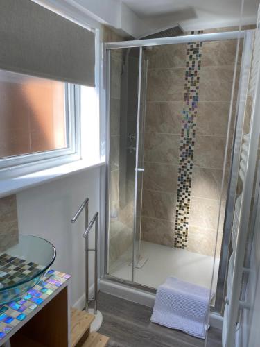 a shower with a glass door in a bathroom at The Wighthill in Sandown