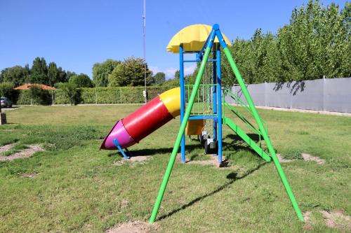 a playground with a slide in a field at Complejo Turístico Natuel in Vista Flores