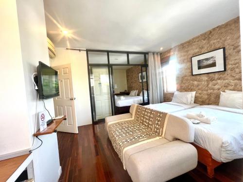 una camera d'albergo con letto e divano di UDEE Cozy Hotel a Chiang Mai