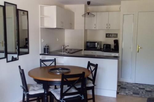 une cuisine avec une table, des chaises et un évier dans l'établissement Côté Lavoir à Honfleur, parking privé, ascenseur, à Honfleur