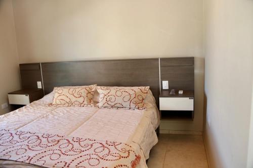 um quarto com uma cama e uma cabeceira em madeira em Complejo Turístico Natuel em Vista Flores