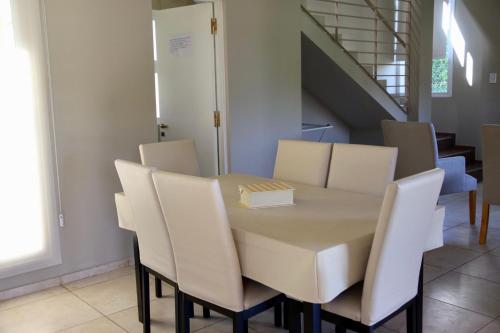 a table with white chairs and a box on it at Complejo Turístico Natuel in Vista Flores