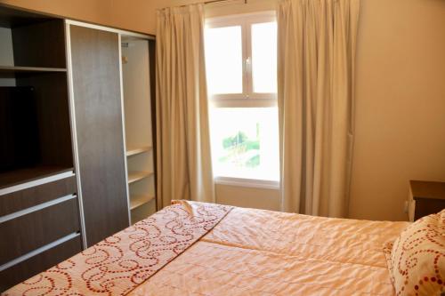a bedroom with a bed and a large window at Complejo Turístico Natuel in Vista Flores