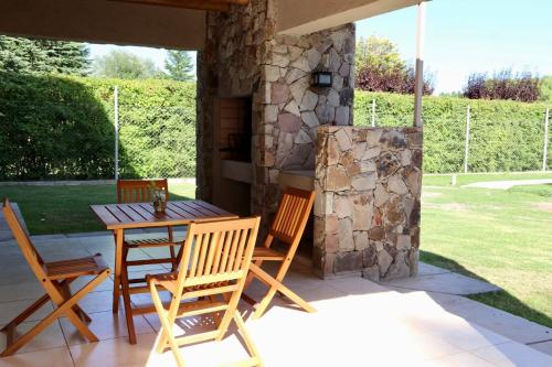 a patio with a table and chairs and a stone oven at Complejo Turístico Natuel in Vista Flores