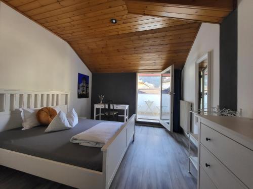 Albergo Gasthof Salurn في سالورنو: غرفة نوم بسرير كبير بسقف خشبي