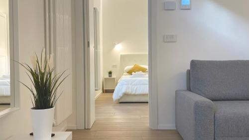 a bedroom with a bed and a couch and a chair at Casa Manzoni Deluxe MXP Town Center in Gallarate