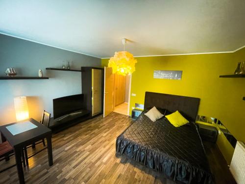 um quarto com uma cama e um quarto com uma mesa em Prima Residence Apartment em Oradea