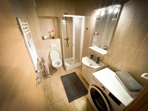 uma casa de banho com um WC, um chuveiro e um lavatório. em Prima Residence Apartment em Oradea