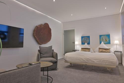 a bedroom with a bed and a couch and a tv at Ferienwohnung UHRWERK in Flensburg