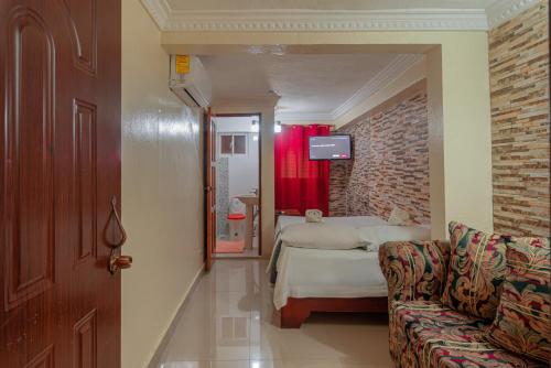 a bedroom with a bed and a couch in a room at Single Room in Corales del Sur - Parque del Este in La Viva