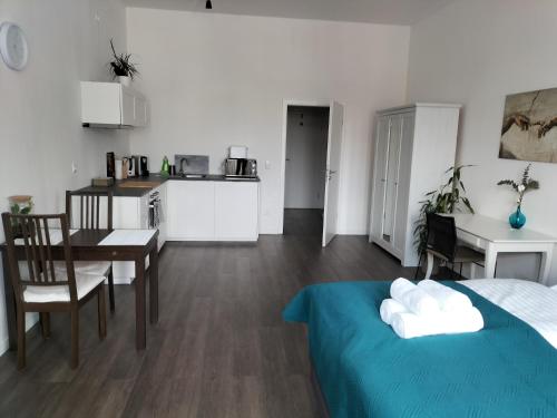 Habitación con cama, mesa y cocina. en Diamera Appartments Zentral und Modern en Hamm