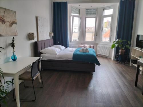 a bedroom with a bed and a desk and windows at Diamera Appartments Zentral und Modern in Hamm