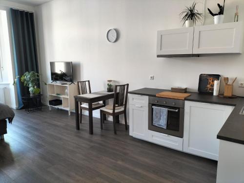 a kitchen with white cabinets and a table with chairs at Diamera Appartments Zentral und Modern in Hamm