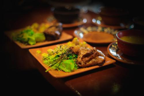 two plates of food on a table with broccoli at Chakana Hotel Boutique Centro in Quito