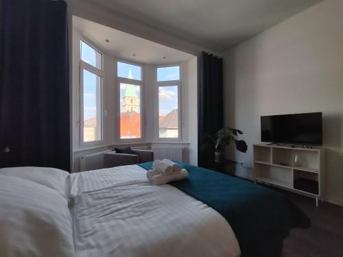 a bedroom with a large bed and a television at Diamera Appartments Zentral und Modern in Hamm