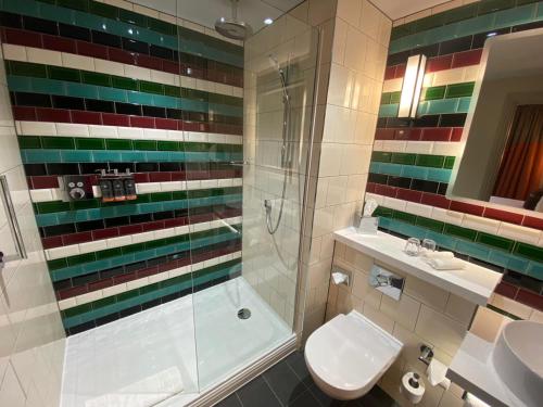 a bathroom with a shower and a toilet and a sink at Hotel Indigo - Cardiff by IHG in Cardiff
