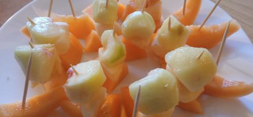 a plate of food with peeled fruit on a stick at A casa di Anna in Vaglio Serra