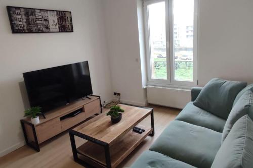 uma sala de estar com um sofá e uma televisão de ecrã plano em Appartement cosy 2 chambres em Nancy