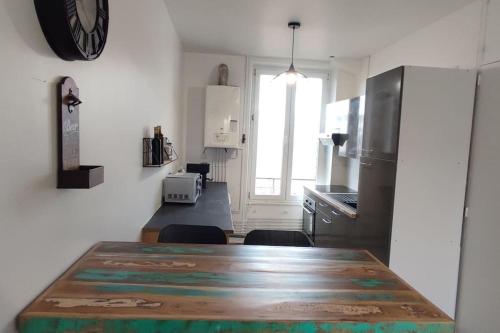 uma cozinha com uma grande mesa de madeira em Appartement cosy 2 chambres em Nancy