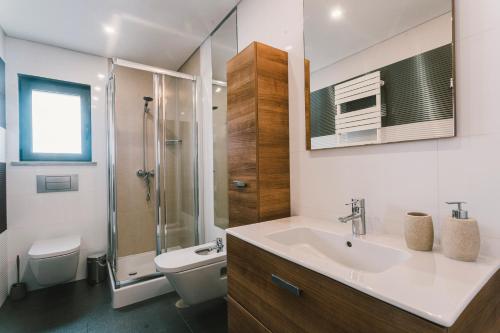 a bathroom with a sink and a shower and a toilet at Bica Luxury Penthouse in Baleal