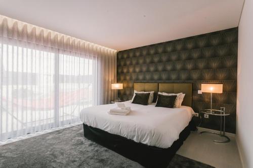 a bedroom with a large bed and a large window at Bica Luxury Penthouse in Baleal