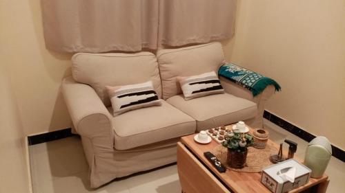 a white couch in a living room with a table at رغيد للشقق الفندقية حائل in Hail