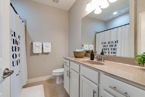 a bathroom with a sink and a toilet and a mirror at Stunning Nashville Condo Minutes from Broadway in Nashville