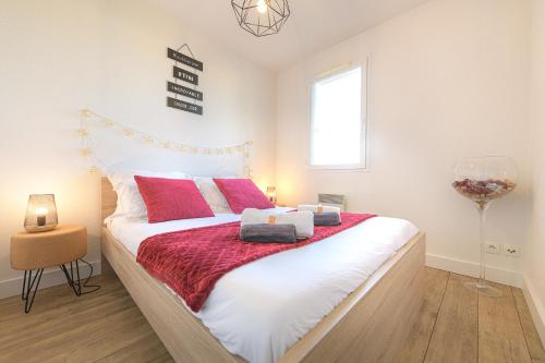 Un dormitorio con una cama grande con almohadas rojas. en Magnifique appartement T2 rénové Aux vendanges Gaillac, en Gaillac