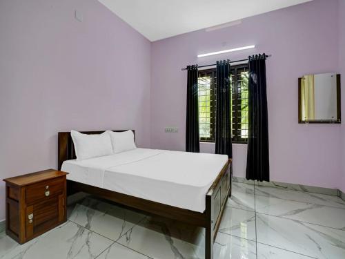 1 dormitorio con cama y ventana en Shalom Palace Residency, en Neriyamangalam