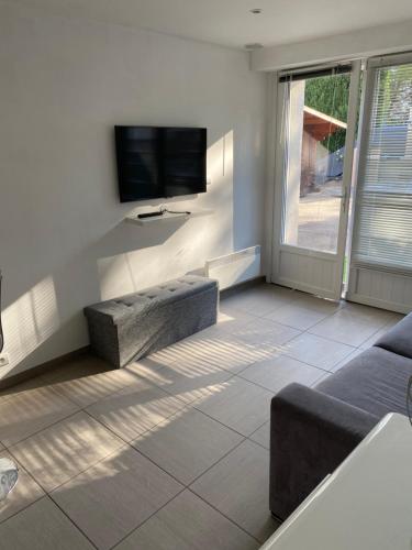 uma sala de estar com um sofá e uma televisão de ecrã plano em Studio avec petit déjeuner em Le Rouret