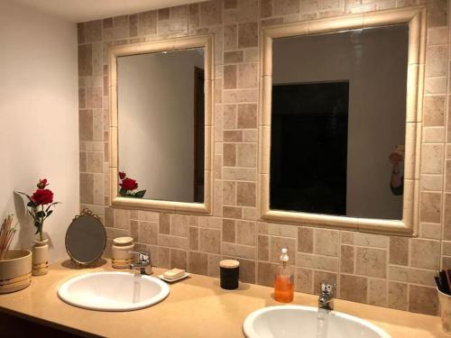 a bathroom with two sinks and two mirrors at Mar y Asados - Chalet hasta 19 huéspedes con dos Parrillas in Mar del Plata