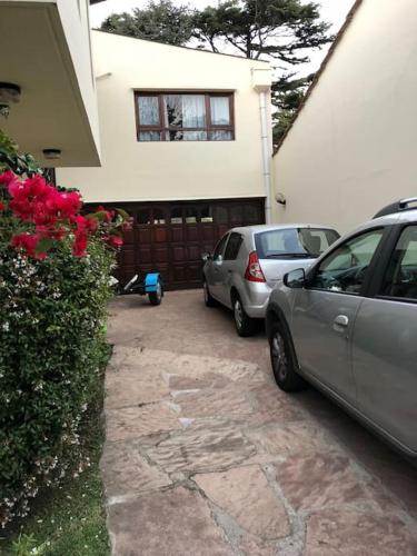 two cars parked in a driveway in front of a house at Mar y Asados - Chalet hasta 19 huéspedes con dos Parrillas in Mar del Plata