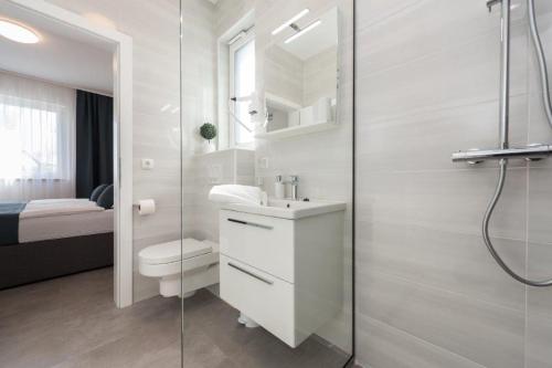 a white bathroom with a toilet and a shower at More Exclusive Villas and Spa in Vir