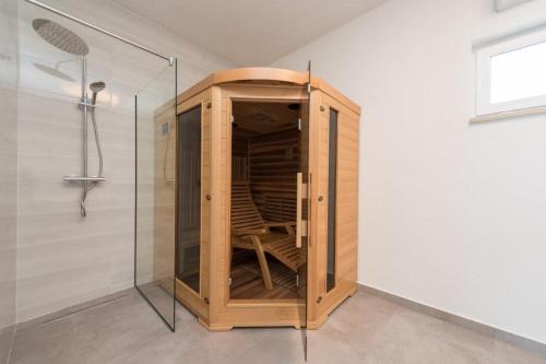un armario de madera en el baño con ducha en More Exclusive Villas and Spa en Vir