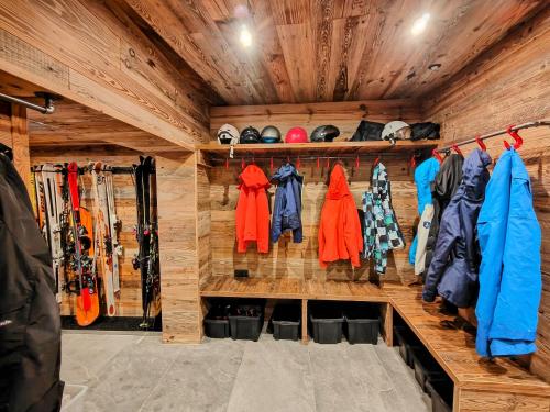 Cette chambre est dotée d'un mur en bois avec des manteaux et des skis. dans l'établissement Chalet Dakota, Pied des pistes, 15 pers, La Plagne, à Plagne 1800
