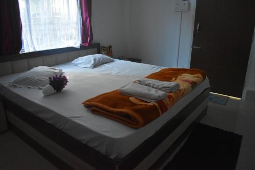 a bed with a blanket and towels on it at Purabi's Nest in Tezpur