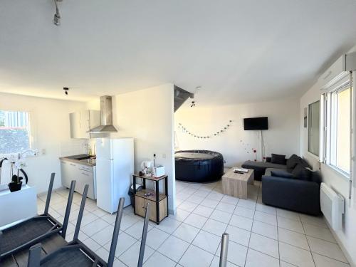 cocina y sala de estar con nevera. en Le Tribord T3 étoilé avec jacuzzi, en Saint-Méloir-des-Ondes